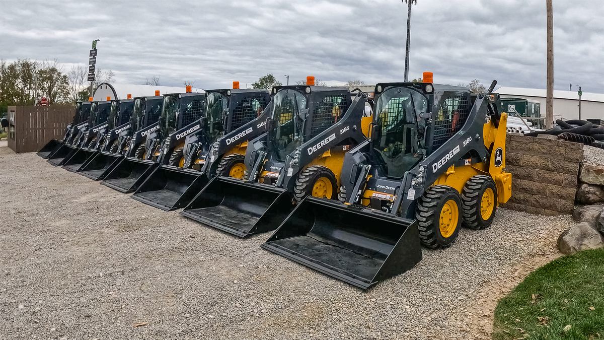 Grunder Landscaping John Deere skid steers lined up with buckets