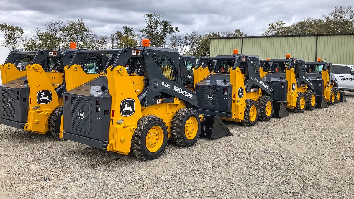 Row of John Deere 318G skid steers in the Grunder Landscaping fleet