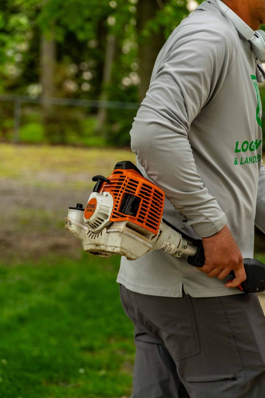 Logan Lawn & Landscaping crew member trimming with a STIHL trimmer