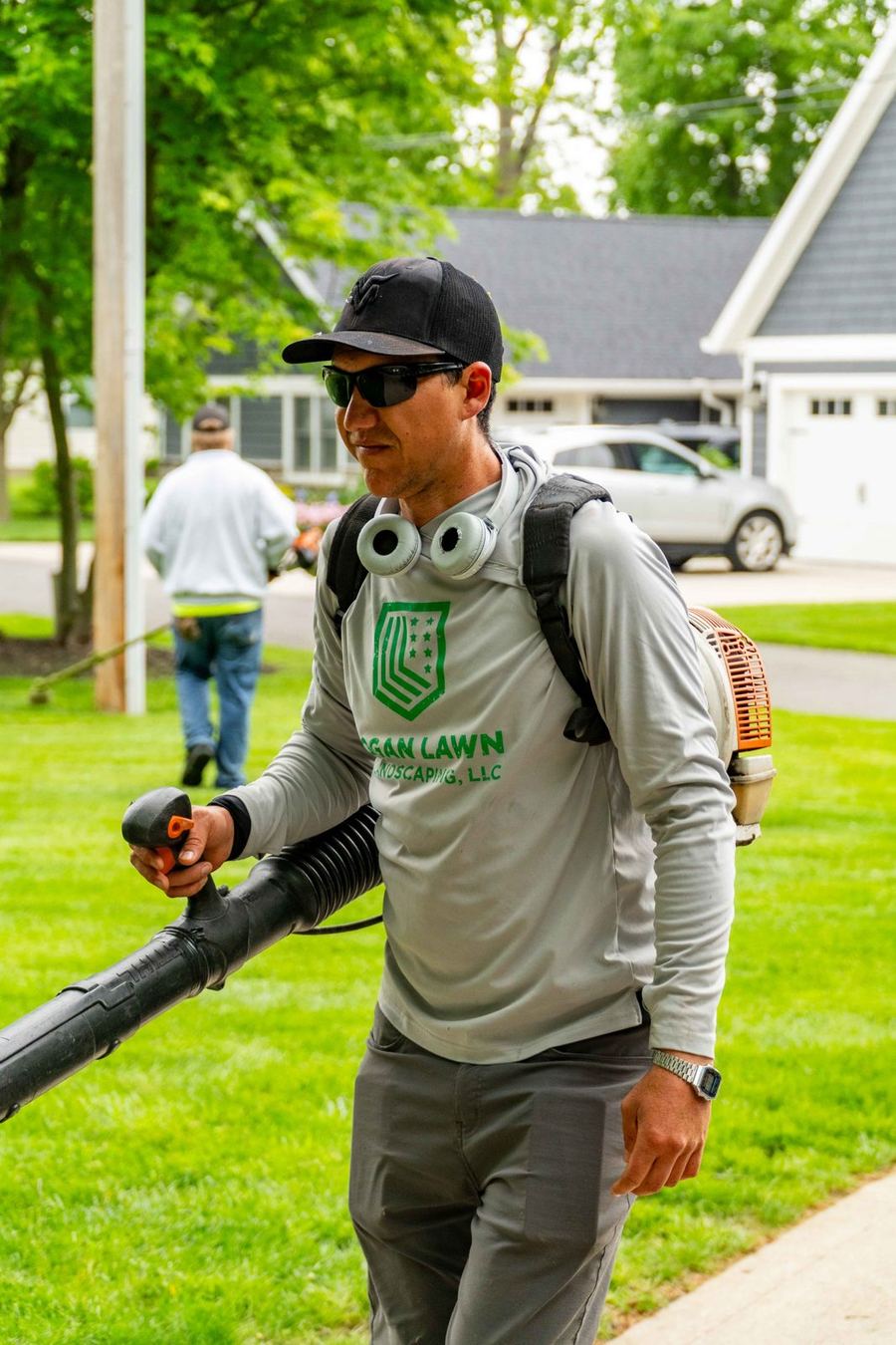 Logan Lawn & Landscaping crew member clearing clippings with a STIHL backpack blower