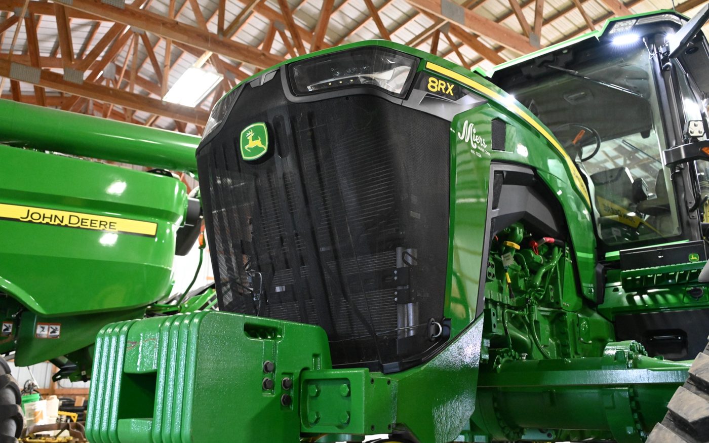 A Miers Farm Corp John Deere 8RX tractor with the Miers decal in the farm shop