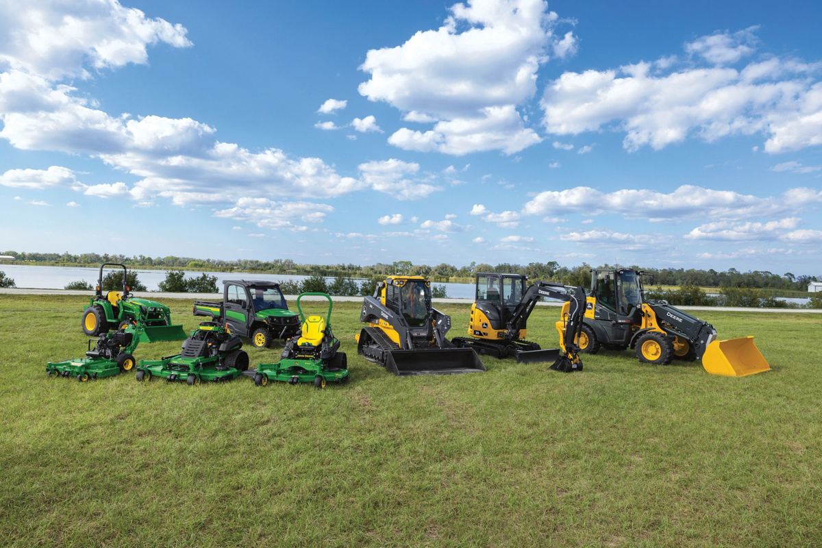 A lineup of John Deere compact tractor, mowers, Gator, compact track loader, excavator, and wheel loader on grass
