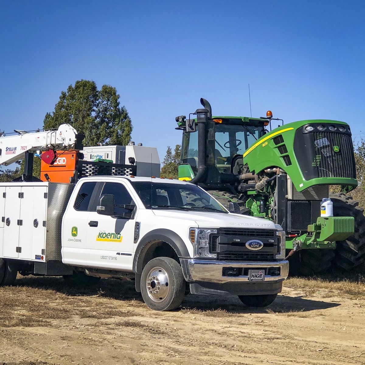 Koenig John Deere service truck with Stellar 7621 crane and EnPak unit next to a John Deere 8630 tractor