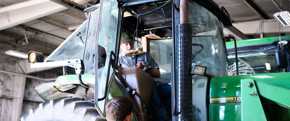 Koenig technicians servicing a John Deere tractor in the shop