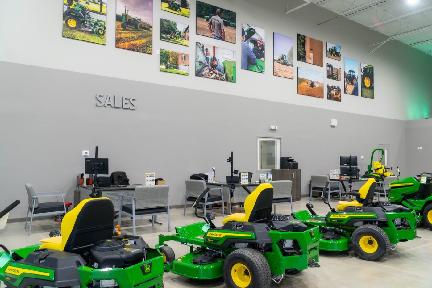 Sales area inside a Koenig Equipment store with John Deere zero-turn and riding mowers on display