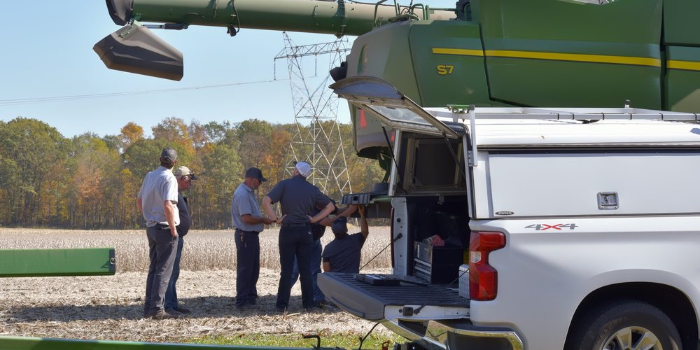 Koenig technicians servicing a John Deere S7 combine in the field from their service truck