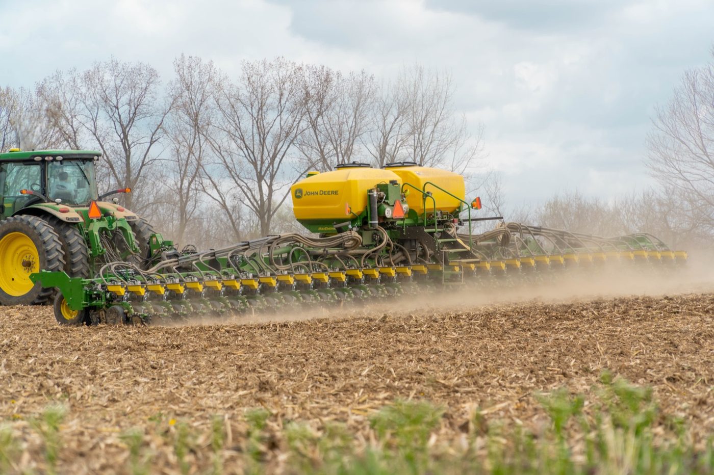 John Deere tractor and planter working a field in spring at a Koenig Customer farm