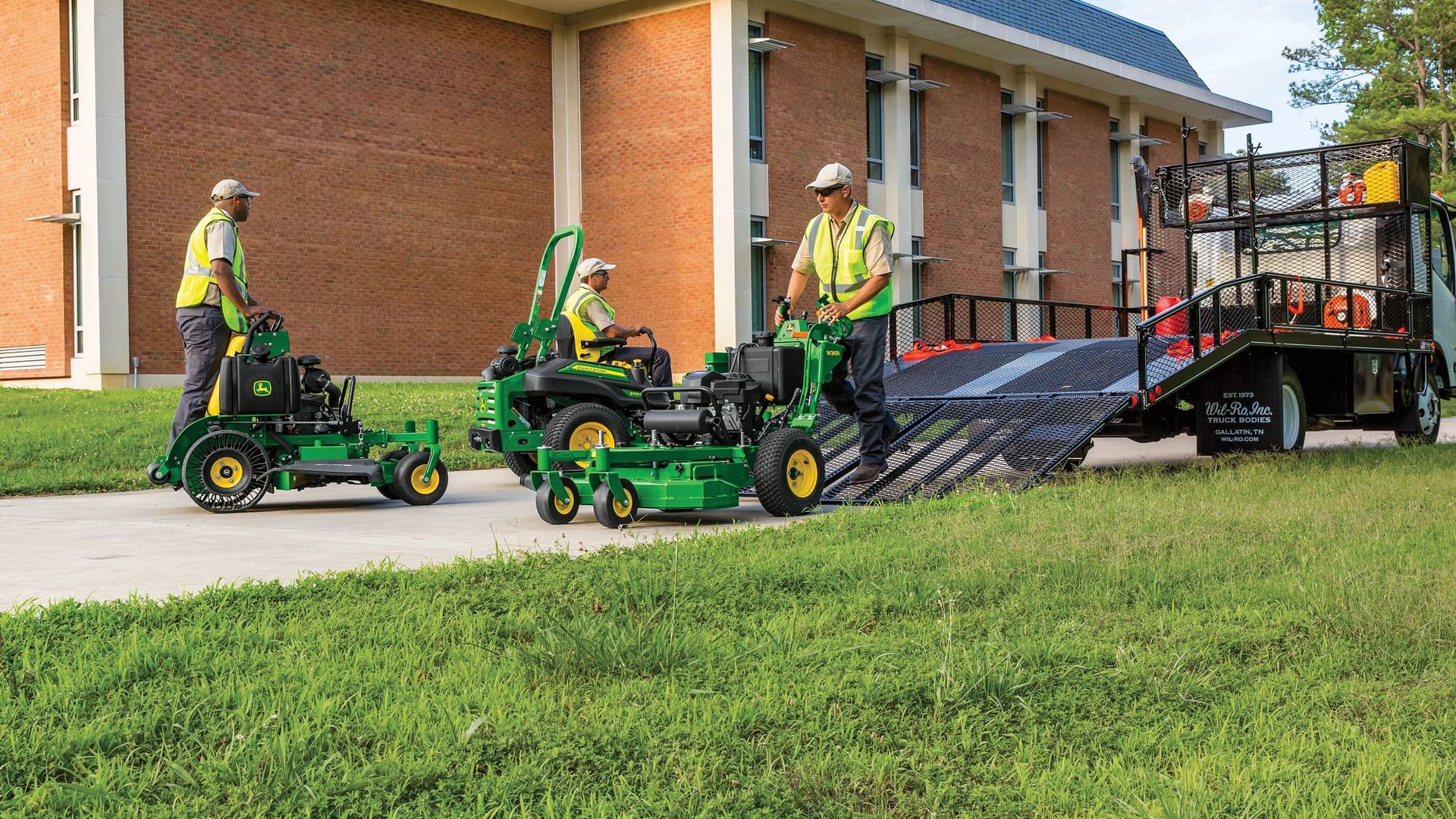Commercial mowing crew with John Deere mowers and a trailer