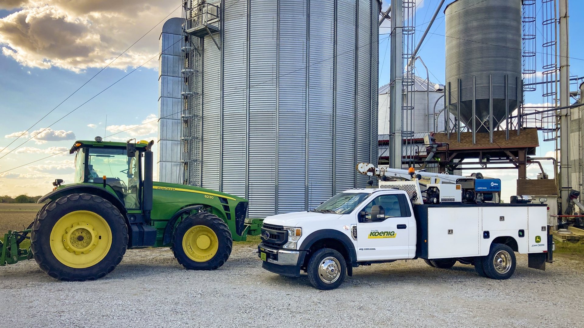 Koenig service truck at a farm with John Deere tractor and grain bins