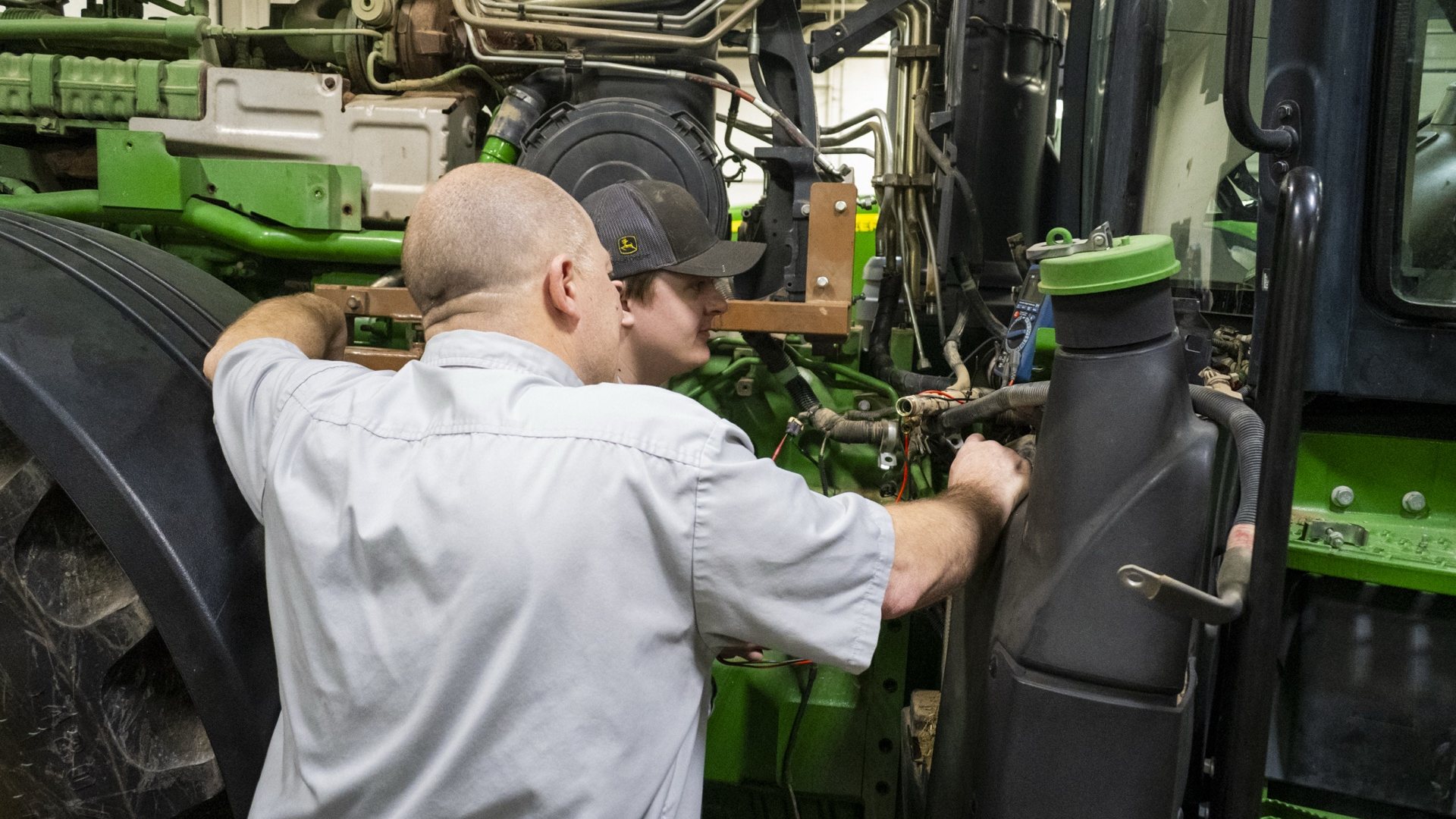 Koenig technicians servicing a John Deere tractor engine