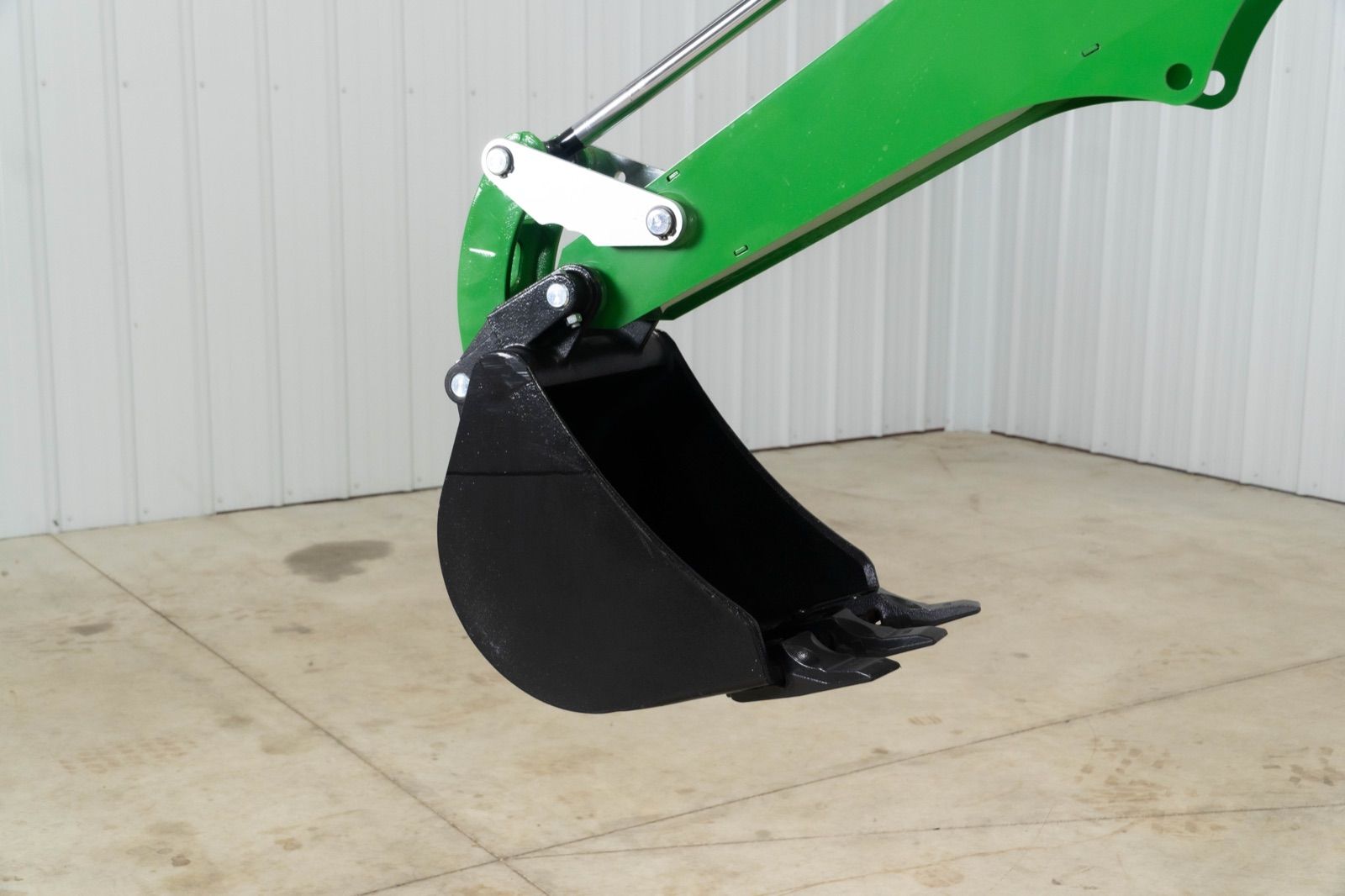 Close-up view of the black bucket of the 260B backhoe attachment on a John Deere tractor