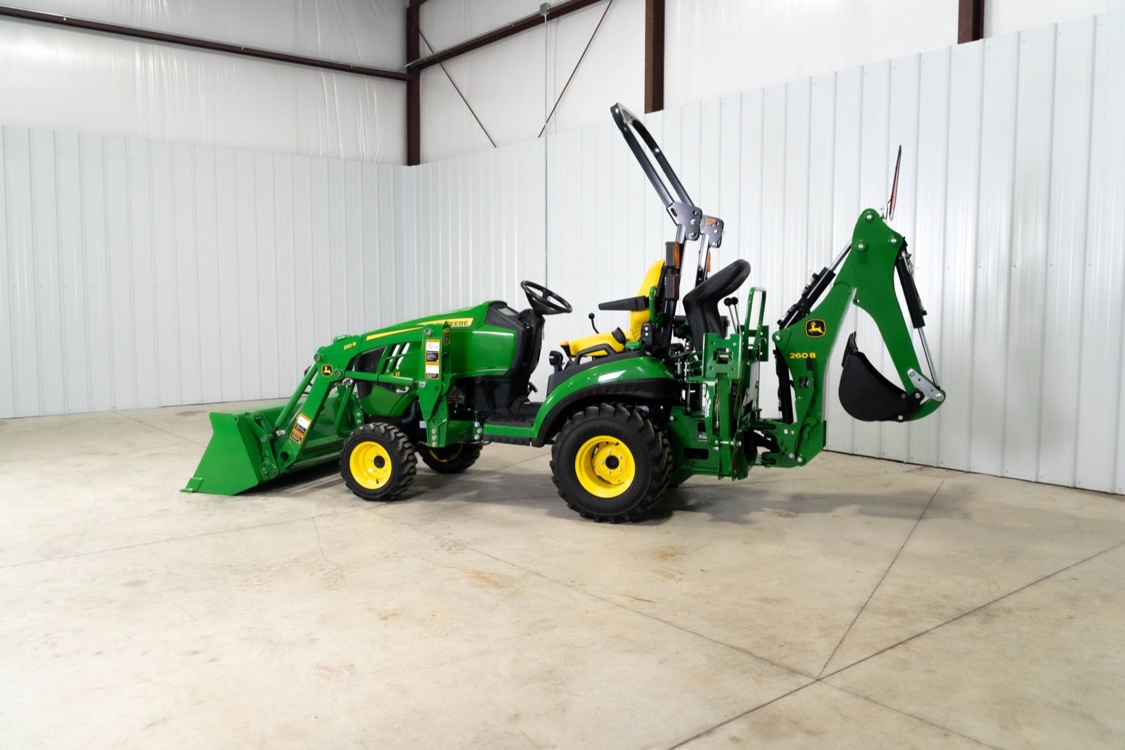 Side view of John Deere 1025R tractor with 120R loader and bucket, and 260B backhoe