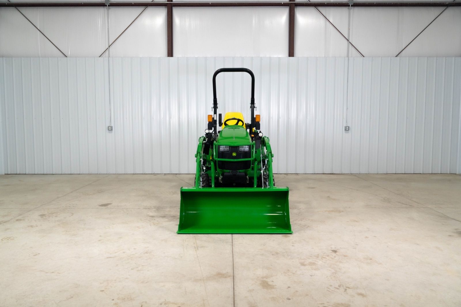 Front view of the John Deere 2025R tractor with 120R loader and bucket attached