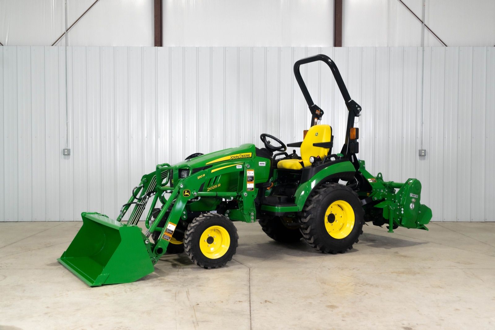 Side view of the John Deere 2025R tractor equipped with a 120R loader and bucket