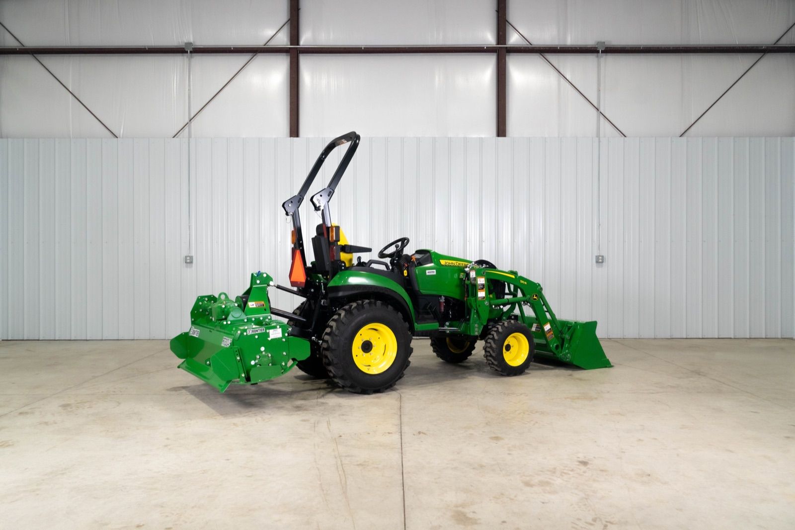 Rear three-quarter view of the John Deere 2025R tractor with 120R loader and RT3049 rotary tiller