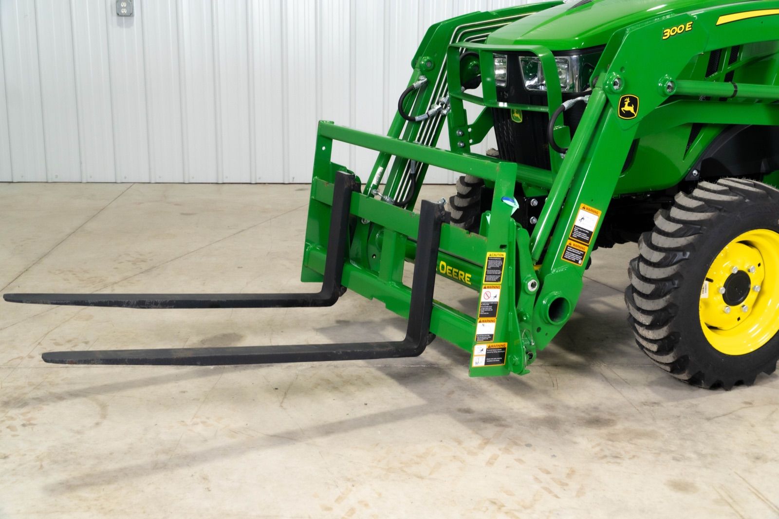 Close-up of the black AP11F pallet forks attached to the 300E loader