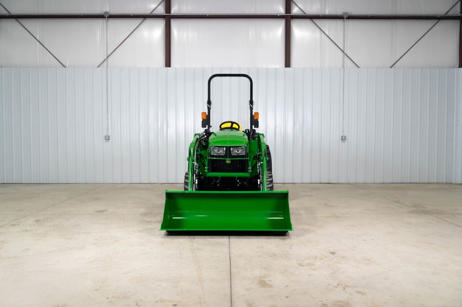 Front view of John Deere 3032E tractor with 300E loader and attached bucket