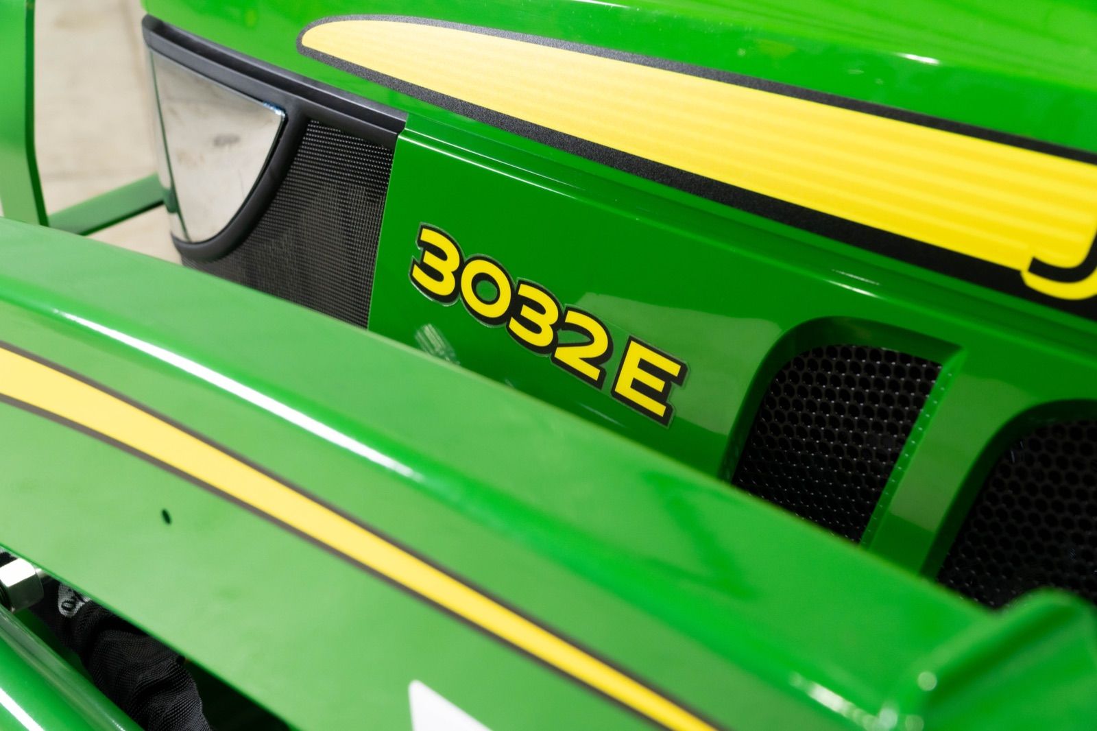 Close-up of the John Deere 3032E tractor hood, showing the '3032E' model number