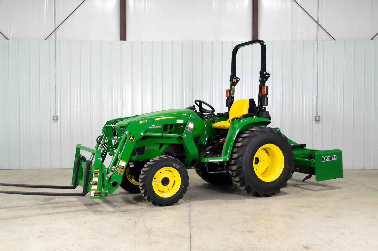 Side view of John Deere 3032E tractor with 300E loader and AP11F pallet forks