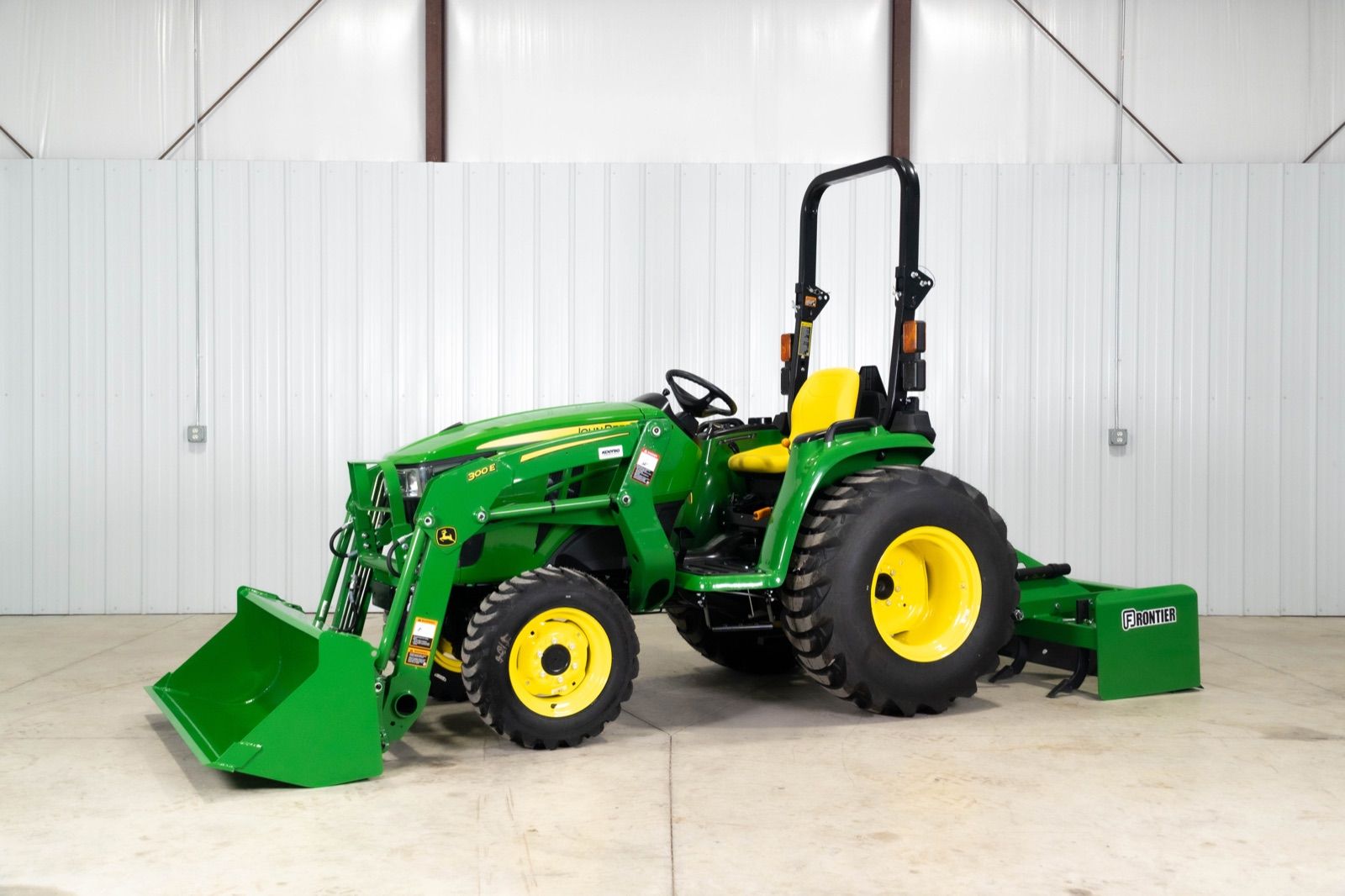 John Deere 3032E tractor with 300E loader and box blade, three-quarter view