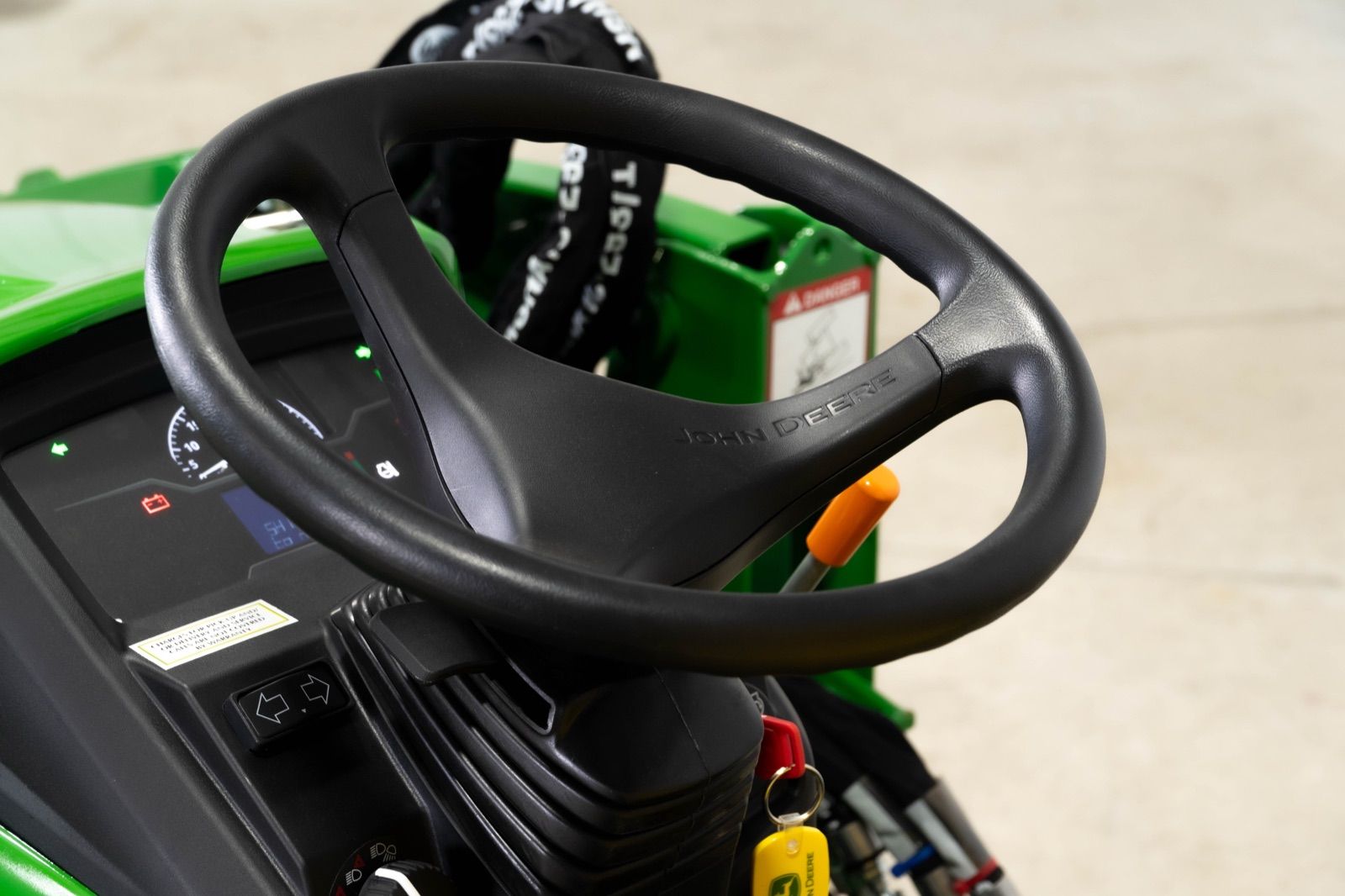 Close-up of the John Deere 1025R tractor's steering wheel and dashboard with gauges