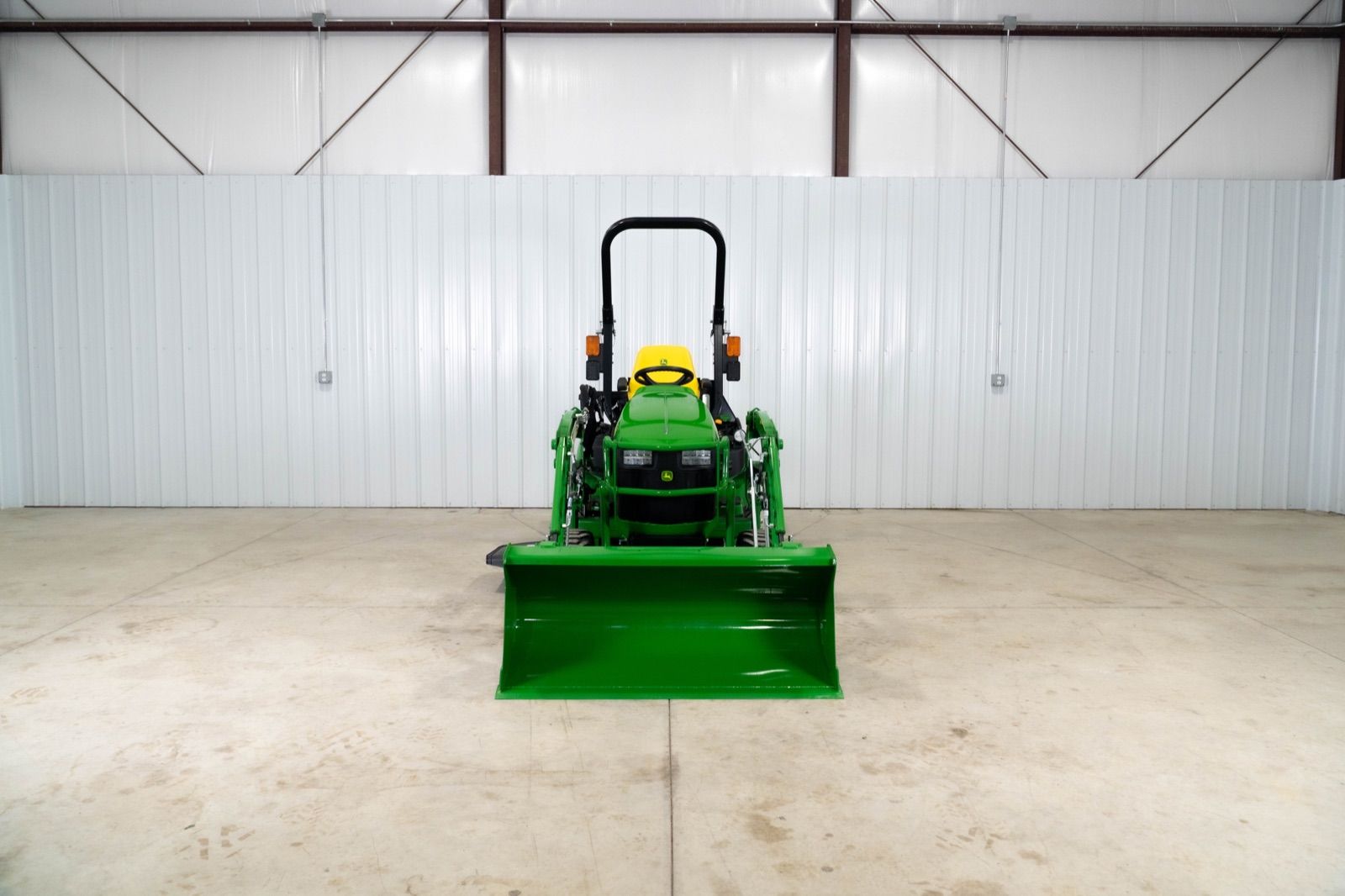 Front view of John Deere 1025R tractor with 120R loader and bucket