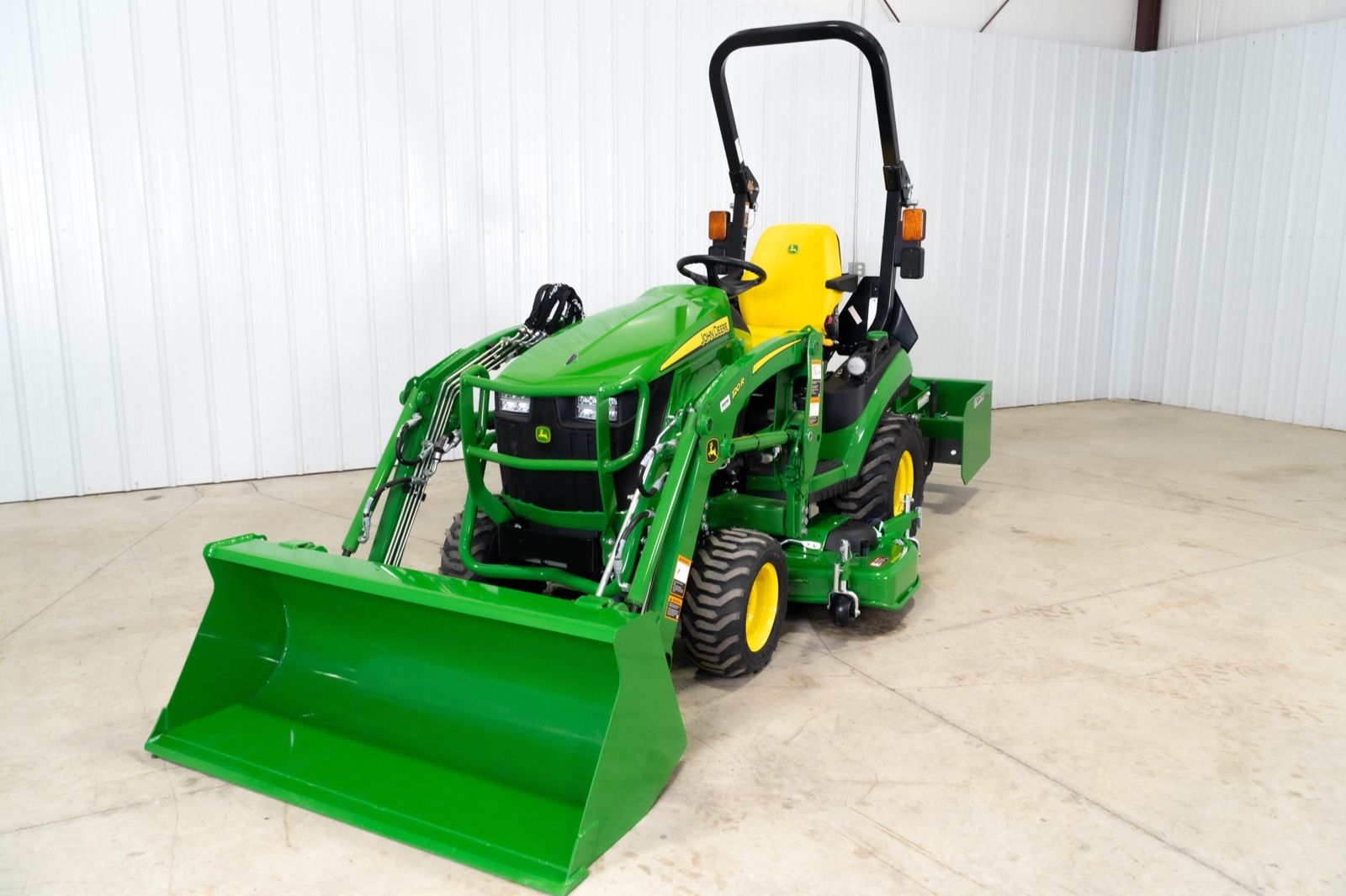 John Deere 1025R tractor with 120R loader and bucket, from front left