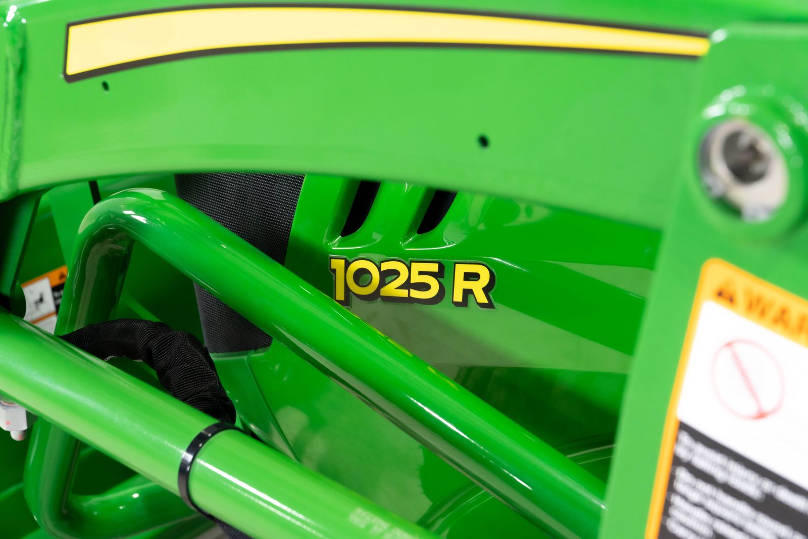 John Deere 1025R model badge on the compact tractor hood