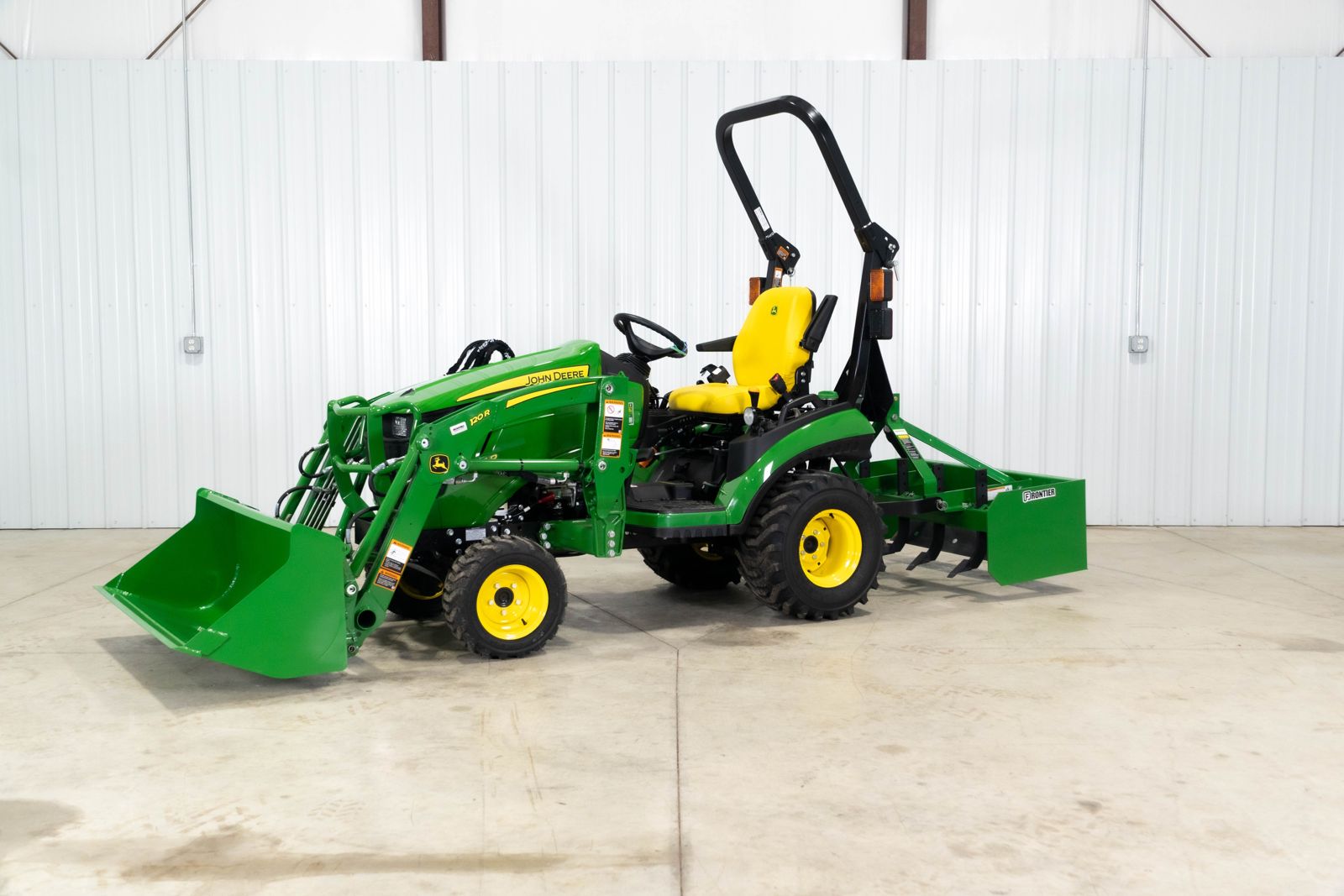 John Deere 1025R Warrior package with 120R loader and BB5048L box blade, front left view