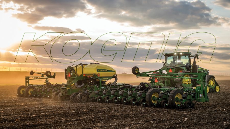 John Deere tractor pulling a planter at sunset